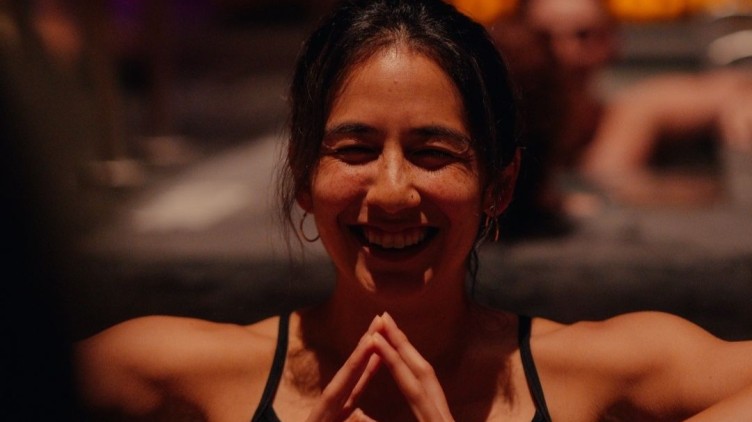 Smiling girl sitting in cold immersion tub.